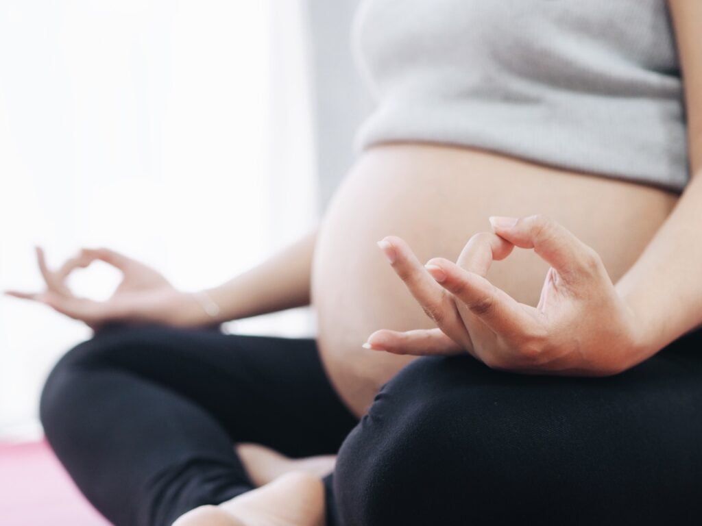 Close up pregnancy woman meditation at home.