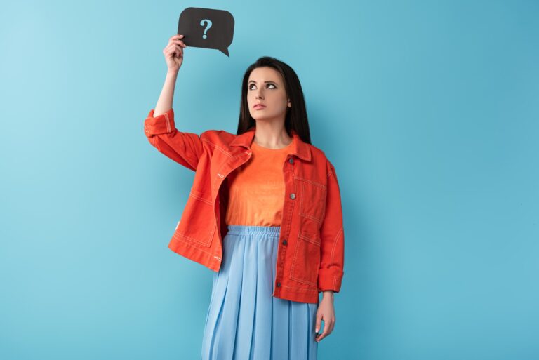 thoughtful woman holding speech bubble with question sign on blue background